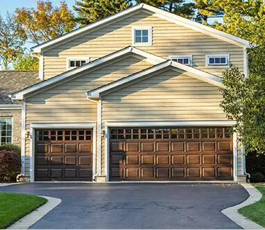 A two car garage with brown doors and white trim.